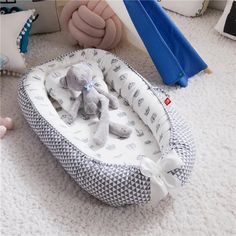 a baby bed with a stuffed animal in it on the floor next to a teddy bear