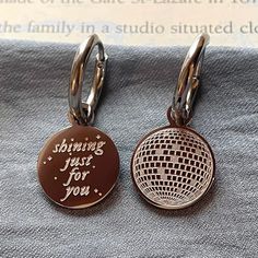 ✿SOLD AS A PAIR (You will receive either 2 silver pieces or 2 gold pieces within ONE order based on what plating color you select Stainless steel mini hoop earrings with 1 charm per hoop. One circle charm with the engraving of a disco ball (mirrorball) on one side & text engraving with sparkles on the other side. (Charm is back-to-back, can be taken off of hoop & flipped). Comes in silver & gold. Perfect for all lovelies who want this special line close.  ✿ Material: stainless steel with high qu Engraved Small Hoop Earrings As Gift, Engraved Small Hoop Earrings For Gift, Silver Engraved Hoop Earrings For Gift, Personalized Silver Dangle Hoop Earrings, Disco Ball Keychain Wedding, Personalized Silver Metal Hoop Earrings, Mirrorball Earrings, Disco Ball Keychain, Disco Key Chains