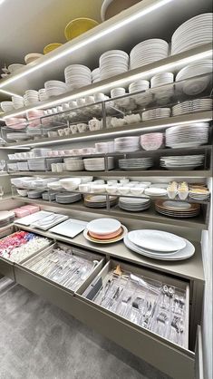 the shelves are filled with plates and other kitchen ware on it's sides,