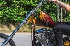 a man riding on the back of a motorcycle with flames painted on it's side