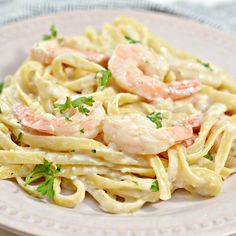 a plate of pasta with shrimp and parsley