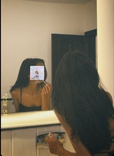 a woman taking a selfie in front of a mirror