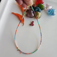 This Glass Seed Bead Necklace consists of White, Turquoise, Red, Light Green, Claret Red, Purple, Orange, Dark Green, Dark Yellow, Glass Seed Beads. Also, the Summer Necklace is perfect for stacking with other necklaces. The seed bead jewelry includes an extension chain of about 1 inch. I used Stainless Steel Jewelry wire, 24K Gold Plated Extension Chain, 24K Gold Plated Lobster Claw. Small Mixed Bead Necklace, Colorful Rainbow Glass Necklace Rainbow Bead Necklace, Seed Bead Necklace, Colorful Necklace Click on the link to see other Multicolored Necklaces, Beaded Chokers. https://www.etsy.com/shop/dkSeedbead?ref=seller-platform-mcnav Summer Rainbow Necklaces With Tiny Beads, Casual Rainbow Beaded Necklace, Seed Bead Necklace Rainbow, Adjustable Rainbow Necklace With Colorful Beads, Mixed Bead Necklace, Vibrant Rainbow Beaded Necklaces, Glass Seed Bead Necklace, Necklaces Beaded, Claret Red