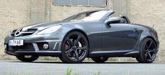 a grey mercedes slk parked in front of a building