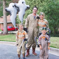 a man and two children are standing in front of an air force pilot with balloons