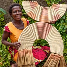 a woman holding two large woven baskets in her hands