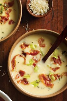 two bowls filled with soup on top of a wooden table