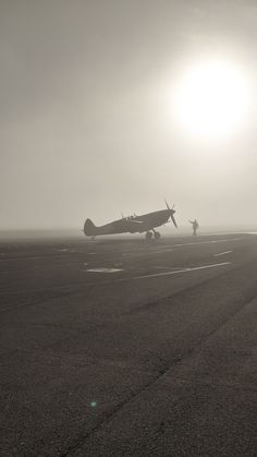 an airplane is sitting on the tarmac in front of the sun, with another plane behind it