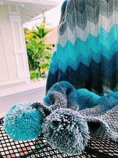 a blue and green blanket sitting on top of a metal basket