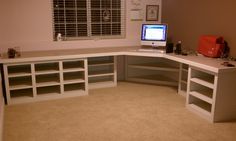 a corner desk with several shelves and a computer monitor on top of it in a room