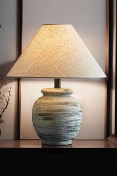 Step into the serene world of Japanese Wabi-Sabi with our Norma Table Lamp a masterpiece of vintage design. Its charming conical cloth lampshade, reminiscent of a traditional straw hat, beautifully complements the rustic ceramic jar base. Together, they create a stunning table lamp that embodies the essence of simplicity and elegance, transporting your space to the heart of tranquil Japanese aesthetics. Cloth Lampshade, Jar Table Lamp, Rustic Ceramics, Energy Efficient Design, Rustic Lamps, Ceramic Jars, Incandescent Bulbs, Design Vintage, Styl Vintage