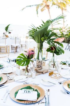 the table is set with place settings and flowers