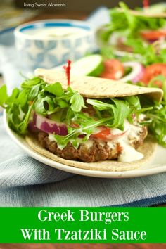 greek burgers with tzatziki sauce and fresh vegetables on a white plate