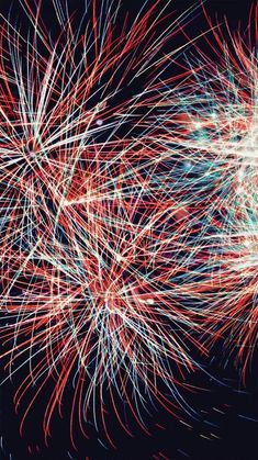 fireworks are lit up in the dark sky with red, white and blue streaks on them