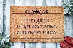 a door mat that says the queen is not accepting audiencess today next to red shoes