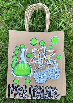 a brown bag with green and blue designs on it sitting in the middle of grass