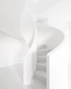 a white spiral staircase in an empty room