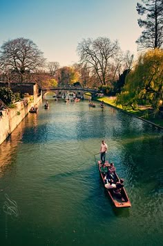 people are riding in small boats down the river