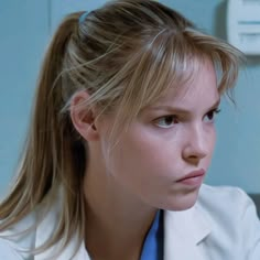 a woman in a lab coat looking at the camera