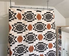 a black and white quilt hanging from a shower curtain