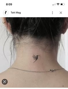 the back of a woman's neck with a small bird tattoo on it