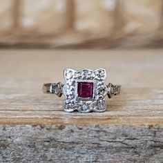 a close up of a ring on a wooden surface with a stone in the middle