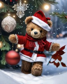 a teddy bear dressed as santa clause standing in front of a christmas tree