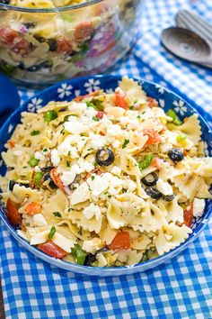 a bowl of pasta salad with olives and tomatoes