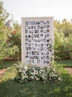 an outdoor photo display with flowers and greenery on the grass in front of it