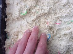 a person's hand on top of some white flour