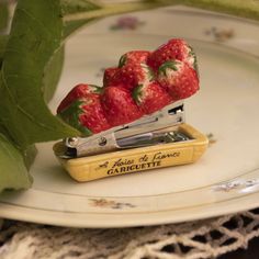 some strawberries are sitting on top of a pair of scissor sharpens