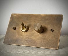 a light switch with two knobs is shown in this close up photo, it appears to be brass