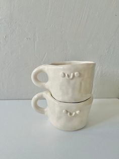 two white cups sitting on top of each other