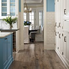 an open kitchen with blue cabinets and wood flooring on the walls, along with hardwood floors