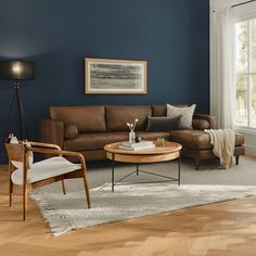 a living room with blue walls and wooden furniture in the corner, along with a large window