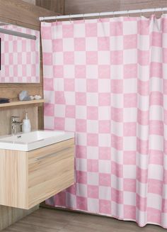 a pink and white checkered shower curtain next to a sink with a mirror above it