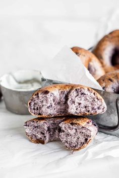 two blueberry donuts sitting on top of each other next to a container of yogurt