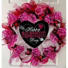 a pink and black valentine's day wreath on a door