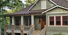 a small gray house with red trim on the front porch and steps leading up to it