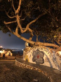 a park bench sitting under a tree at night