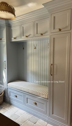 a kitchen with white cabinets and a bench