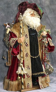 a statue of santa claus holding a cane and wearing a red outfit with gold trim