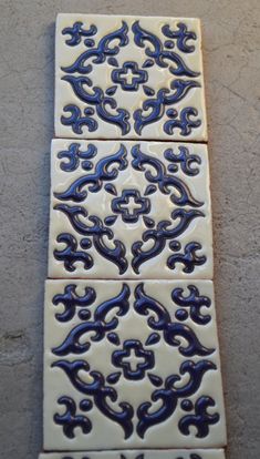 three blue and white tiles sitting on top of a floor