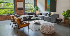 a living room filled with lots of furniture next to a large painting on the wall