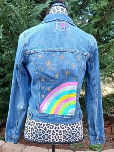 a woman's jean jacket with an image of a rainbow on it