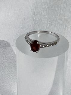 Lots of sparkle in this delicate garnet solitaire ring.  Faceted, prong set oval garnet held high over the gallery and set off each side with a series of brilliant faceted crystals on the shoulders.  On my mandrel the ring size is 7 3/8.  I try to provide as much information as possible about the size of a ring but if more measurements are needed please contact me before purchase and I will be happy to assist.   The garnet measures approx. 7 mm by 5 mm (9/32" x 3/16").  Weighs approx. 1.7 grams. Faceted Crystal, Stacking Rings, Solitaire Ring, The Gallery, Rings Statement, Wedding Shop, Prong Setting, Statement Rings, Garnet