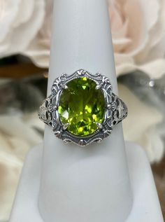 "Natural Green Peridot Ring Description Beauty Design#229 MADE To ORDER This is a brand new stunning Art Nouveau/Victorian reproduction sterling silver filigree ring. The oval-cut high-quality natural peridot is 12mm by 10mm (just shy of 3/8\" inch) in dimension... The ring is 5/8th of an inch (16.5mm) NS (long) on the finger. The ring and gem sit 7mm off the finger. The inside of the band is marked 925 for sterling. Notice the beautiful filigree swirl like the craftsmanship of the silver settin Oval Peridot Gemstones For Anniversary, Antique Oval May Birthstone Rings, Antique Oval Rings For May Birthstone, Oval May Birthstone Gemstone With Center Stone, Green Oval Filigree Ring In Sterling Silver, Oval Peridot Ring In White Gold, Oval Peridot Jewelry For Formal Occasions, Victorian Oval Ring For May Birthstone, Victorian Oval Emerald Ring As Gift