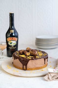 a chocolate cheesecake on a plate with a bottle of bailey's