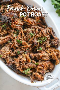 french onion pot roast in a white casserole dish with parsley on the side