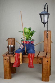 a potted plant sitting on top of a wooden bench next to a lamp post